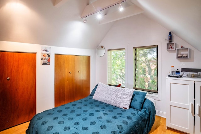 2512 N Marshfield Ave, Chicago, IL 60614 - bedroom with rail lighting, lofted ceiling, and light wood-style floors