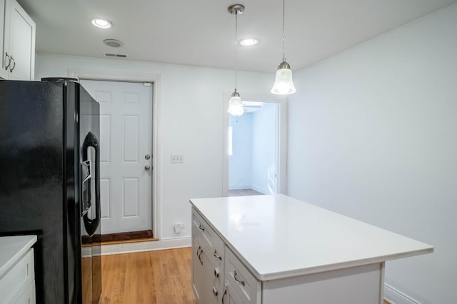 2512 N Marshfield Ave, Chicago, IL 60614 - kitchen featuring black fridge, light countertops, light wood finished floors, white cabinets, and recessed lighting