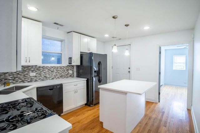 2512 N Marshfield Ave, Chicago, IL 60614 - kitchen with black appliances, a sink, decorative backsplash, a center island, and light wood-style flooring