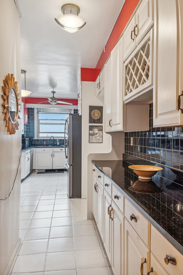 5000 S E End Ave Unit 13A, Chicago, IL 60615 - kitchen featuring appliances with stainless steel finishes, backsplash, dark countertops, a sink, and light tile patterned flooring
