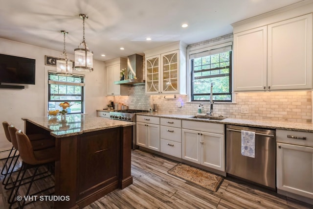 723 Gardner Rd, Flossmoor, IL 60422 - kitchen with appliances with stainless steel finishes, wall chimney exhaust hood, a breakfast bar area, decorative backsplash, and a center island