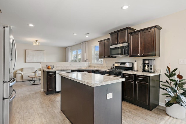 315 Maryland Ln, Pingree Grove, IL 60140 - kitchen with stainless steel appliances, a peninsula, a sink, light wood-type flooring, and dark brown cabinets