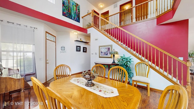 105 Grandview Ct, Volo, IL 60020 - dining space featuring wood finished floors, a towering ceiling, stairs, and baseboards
