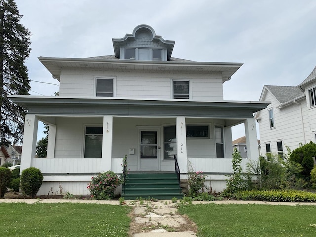american foursquare style home with a porch and a front lawn