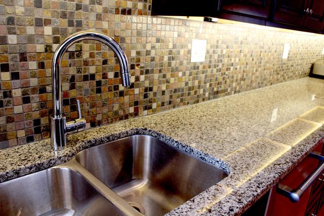 5484 S Hyde Park Blvd, Chicago, IL 60615 - kitchen view of a sink, backsplash, and light stone countertops