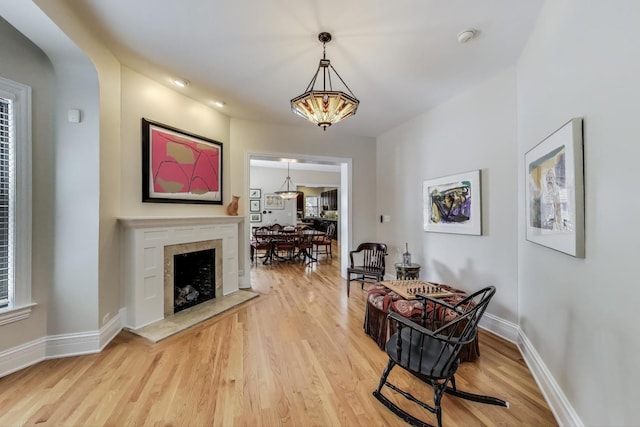 5484 S Hyde Park Blvd, Chicago, IL 60615 - dining space featuring light wood-type flooring, baseboards, a fireplace with raised hearth, and arched walkways