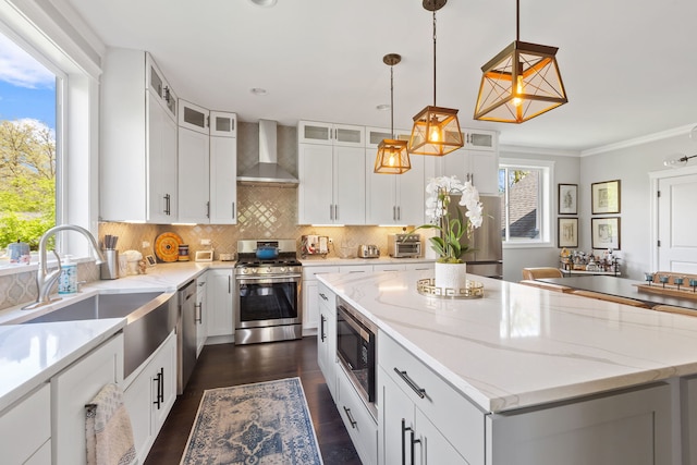 589 Quassey Ave, Lake Bluff, IL 60044 - kitchen with wall chimney exhaust hood, appliances with stainless steel finishes, a sink, a center island, and light stone counters