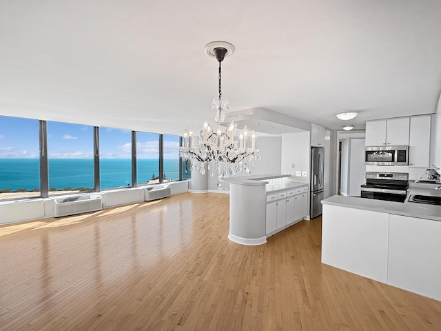 505 N Lake Shore Dr Unit 4105, Chicago, IL 60611 - kitchen featuring appliances with stainless steel finishes, a chandelier, light wood finished floors, a peninsula, and white cabinets