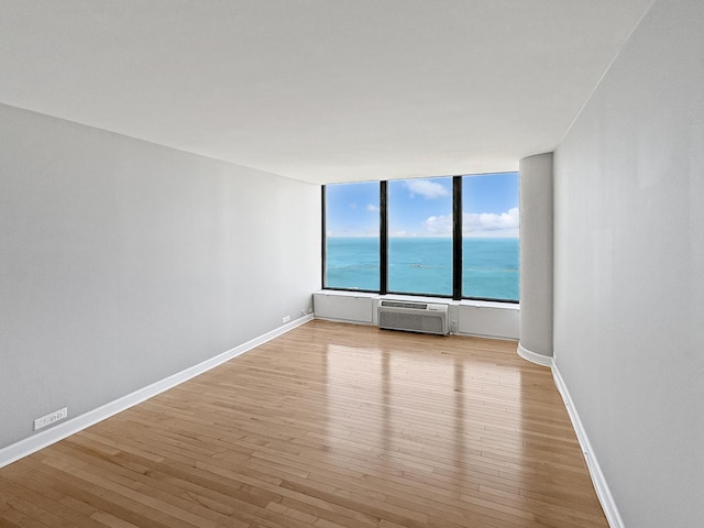 505 N Lake Shore Dr Unit 4105, Chicago, IL 60611 - spare room featuring a wall mounted AC, light wood-style floors, baseboards, and a water view