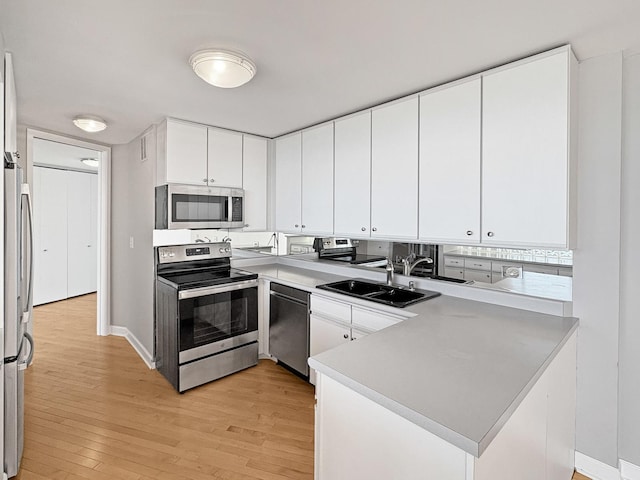 505 N Lake Shore Dr Unit 4105, Chicago, IL 60611 - kitchen featuring appliances with stainless steel finishes, light wood-style floors, a sink, a peninsula, and white cabinetry