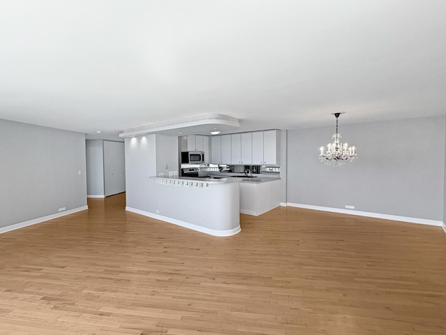 505 N Lake Shore Dr Unit 4105, Chicago, IL 60611 - kitchen featuring stainless steel microwave, open floor plan, a chandelier, and light wood-style flooring