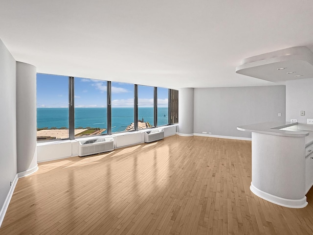 505 N Lake Shore Dr Unit 4105, Chicago, IL 60611 - unfurnished living room with wood finished floors, a water view, a wall unit AC, and baseboards