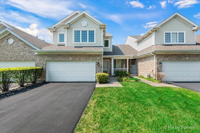 18104 Lake Shore Dr, Orland Park, IL 60467 - traditional home featuring a garage, asphalt driveway, a front lawn, brick siding, and a shingled roof