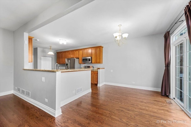 18104 Lake Shore Dr, Orland Park, IL 60467 - kitchen featuring appliances with stainless steel finishes, a chandelier, wood finished floors, baseboards, and decorative light fixtures