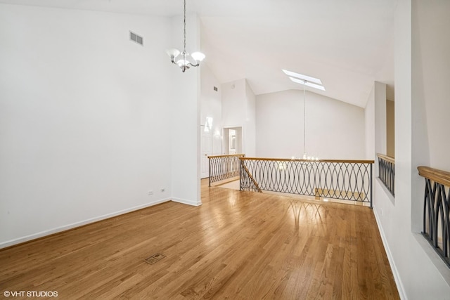 3305 Old Glenview Rd Unit A, Wilmette, IL 60091 - unfurnished living room featuring a chandelier, wood finished floors, a skylight, baseboards, and high vaulted ceiling