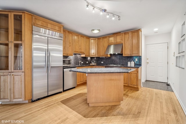 3305 Old Glenview Rd Unit A, Wilmette, IL 60091 - kitchen with appliances with stainless steel finishes, under cabinet range hood, a kitchen island, a sink, and decorative backsplash