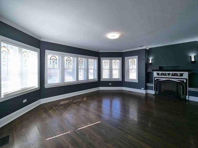 unfurnished living room with baseboards, wood finished floors, a fireplace, and crown molding