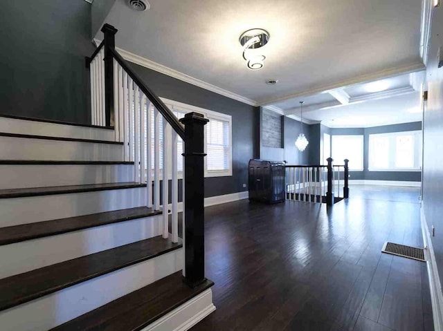 stairway with baseboards, crown molding, wood finished floors, coffered ceiling, and beam ceiling