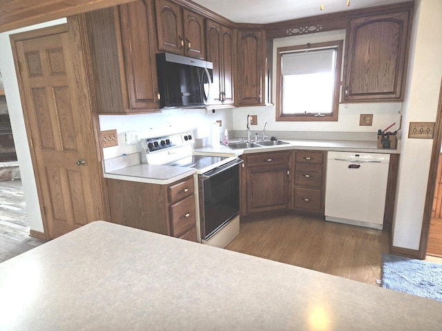 1988 S Chana Rd, Chana, IL 61015 - kitchen featuring white appliances, a sink, wood finished floors, and light countertops