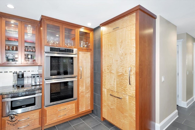 616 E Hillside Ave, Barrington, IL 60010 - kitchen with stainless steel appliances, dark tile patterned flooring, glass insert cabinets, recessed lighting, and dark stone countertops