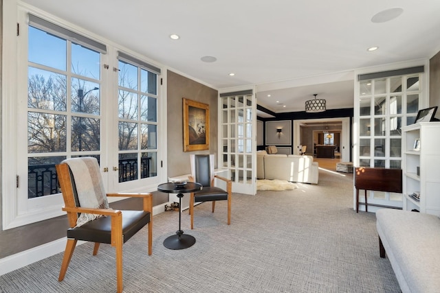 living area featuring carpet flooring, crown molding, baseboards, and recessed lighting