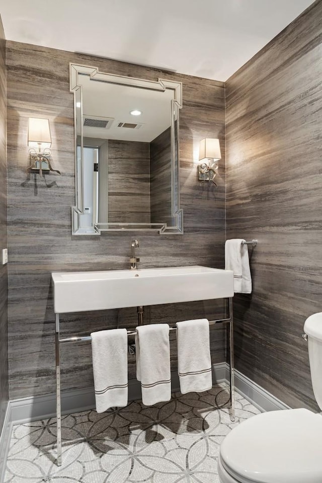 bathroom featuring toilet, vanity, and baseboards