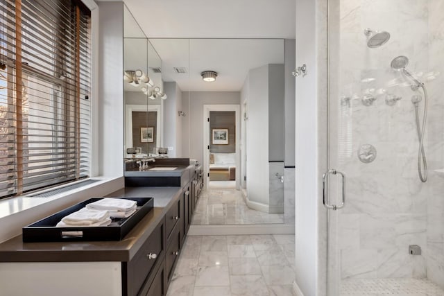 full bath with marble finish flooring, a stall shower, plenty of natural light, and vanity
