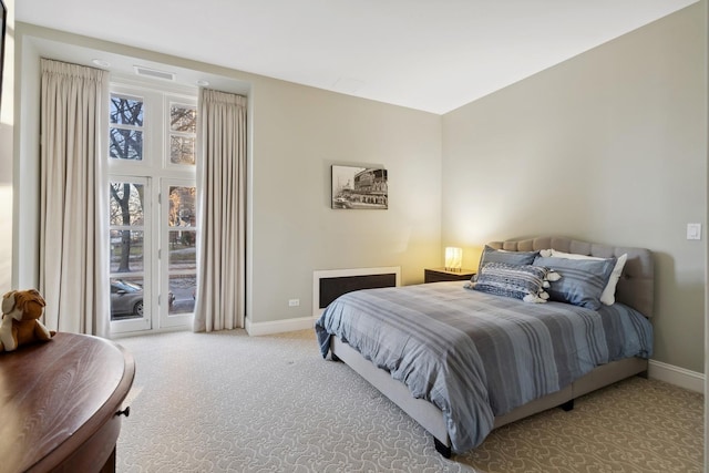 carpeted bedroom with baseboards and access to exterior