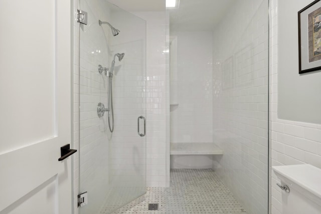 full bathroom with a stall shower, toilet, and tile walls
