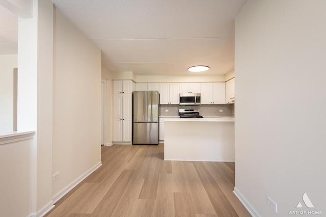 3940 W Bryn Mawr Ave Unit 403, Chicago, IL 60659 - kitchen with stainless steel appliances, light wood-style flooring, white cabinets, backsplash, and a peninsula