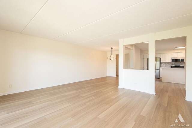 3940 W Bryn Mawr Ave Unit 403, Chicago, IL 60659 - unfurnished living room with light wood-type flooring, a chandelier, and baseboards