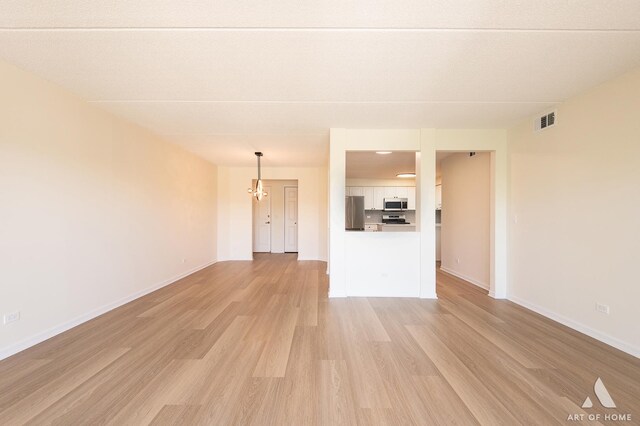 3940 W Bryn Mawr Ave Unit 403, Chicago, IL 60659 - unfurnished living room featuring light wood finished floors, baseboards, and a chandelier