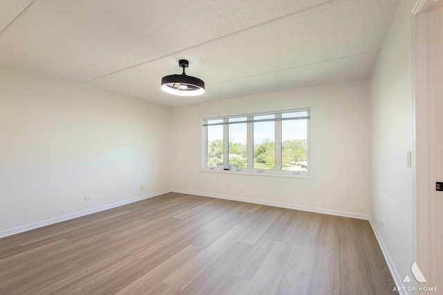 3940 W Bryn Mawr Ave Unit 403, Chicago, IL 60659 - spare room featuring light wood-style floors, baseboards, and a textured ceiling