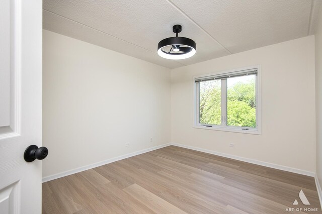 3940 W Bryn Mawr Ave Unit 403, Chicago, IL 60659 - unfurnished room with light wood-type flooring, baseboards, and a textured ceiling