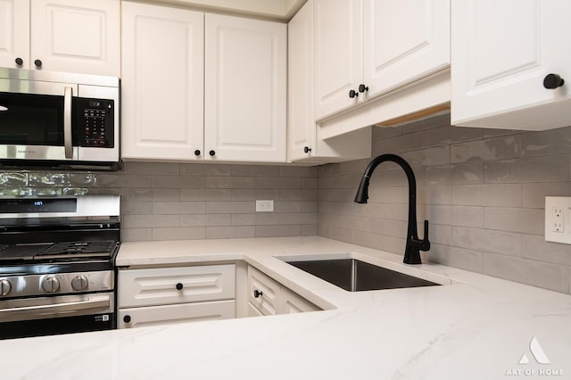 3940 W Bryn Mawr Ave Unit 403, Chicago, IL 60659 - kitchen with appliances with stainless steel finishes, a sink, white cabinets, backsplash, and light stone countertops