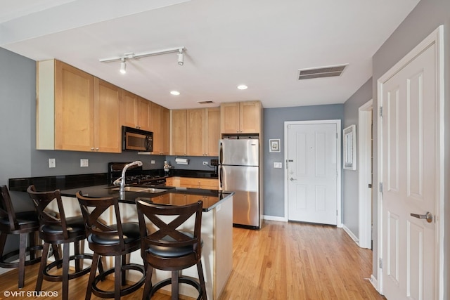 437 W N Ave Unit 404, Chicago, IL 60610 - kitchen with freestanding refrigerator, black microwave, a peninsula, dark countertops, and a kitchen bar