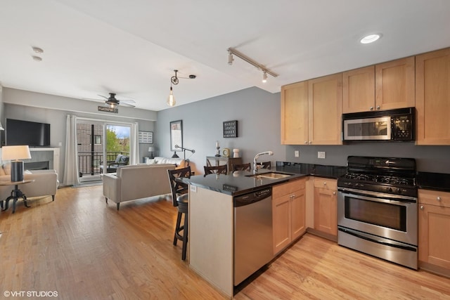 437 W N Ave Unit 404, Chicago, IL 60610 - kitchen featuring stainless steel appliances, open floor plan, a peninsula, light brown cabinets, and track lighting