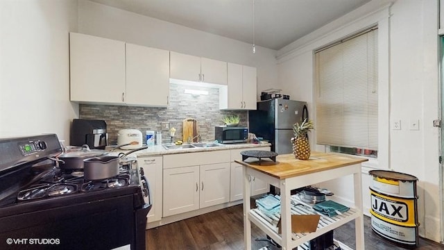 1655 N Francisco Ave, Chicago, IL 60647 - kitchen featuring stainless steel appliances, light countertops, tasteful backsplash, white cabinets, and dark wood-type flooring