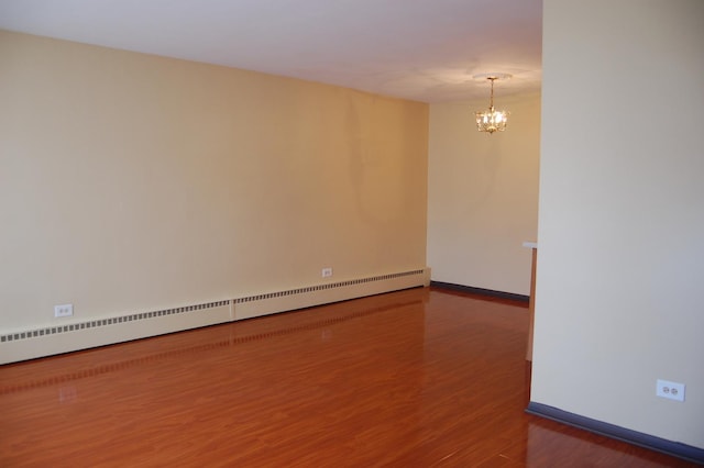 1001 N Harlem Ave Unit A, Oak Park, IL 60302 - spare room featuring a baseboard heating unit, wood finished floors, a chandelier, and baseboards
