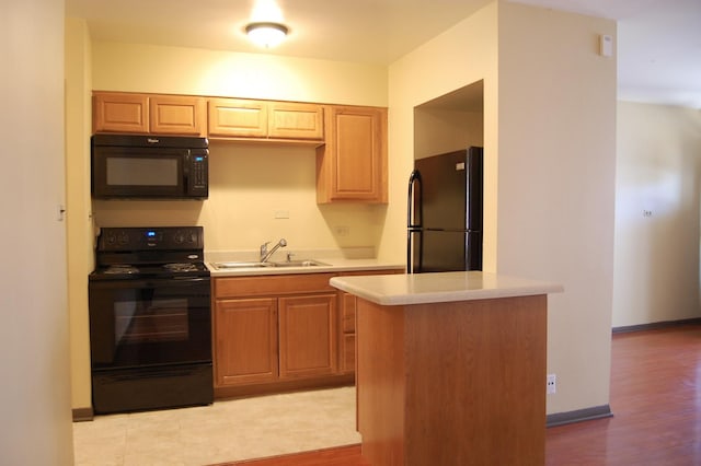 1001 N Harlem Ave Unit A, Oak Park, IL 60302 - kitchen with black appliances, a sink, light countertops, and light wood finished floors