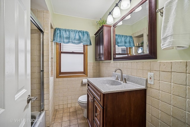 4101 N Ozark Ave, Norridge, IL 60706 - bathroom featuring toilet, vanity, tile patterned flooring, tile walls, and enclosed tub / shower combo