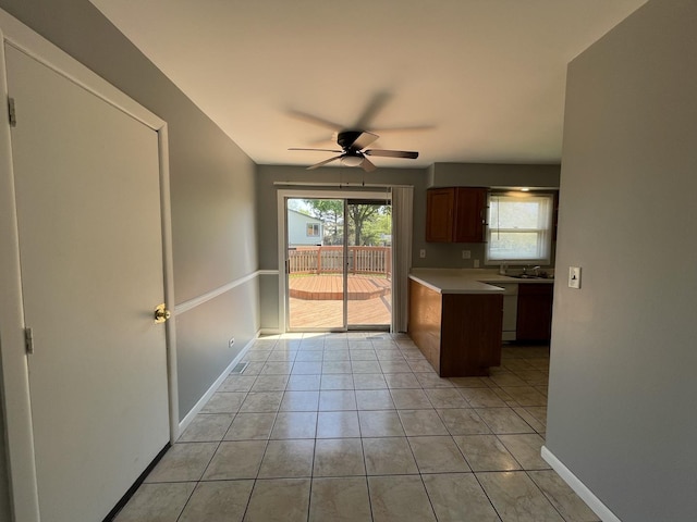 235 Lexington Dr, Bolingbrook, IL 60440 - kitchen featuring a ceiling fan, a peninsula, light tile patterned floors, light countertops, and baseboards