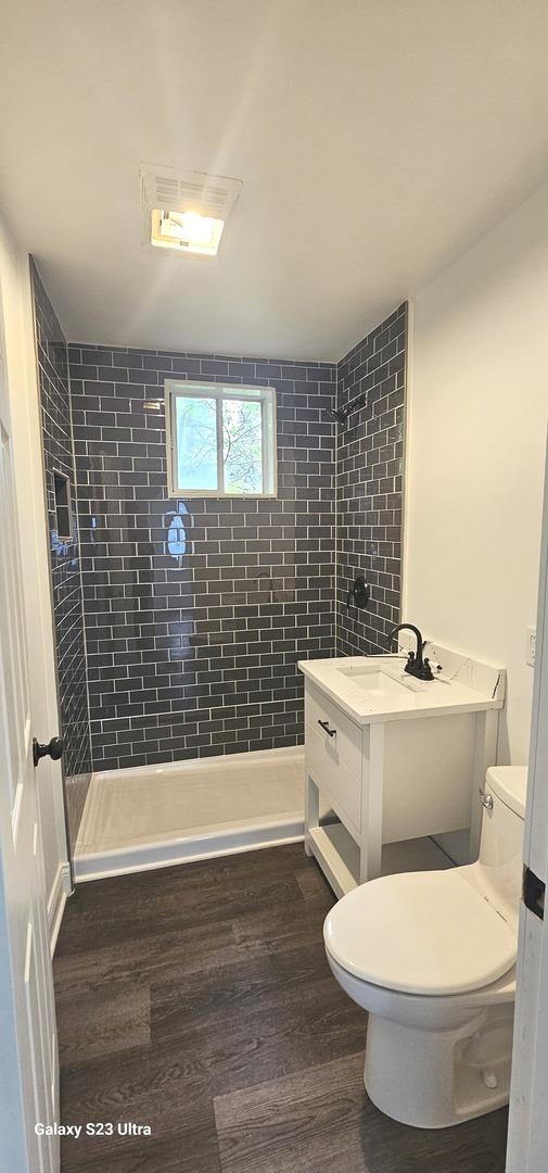 307 Bevier Pl, Aurora, IL 60505 - full bath featuring a sink, toilet, a stall shower, and wood finished floors