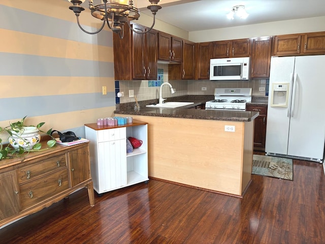 1127 N Red Oak Cir Unit 2, Round Lake Beach, IL 60073 - kitchen with white appliances, a sink, a chandelier, a peninsula, and dark wood-type flooring