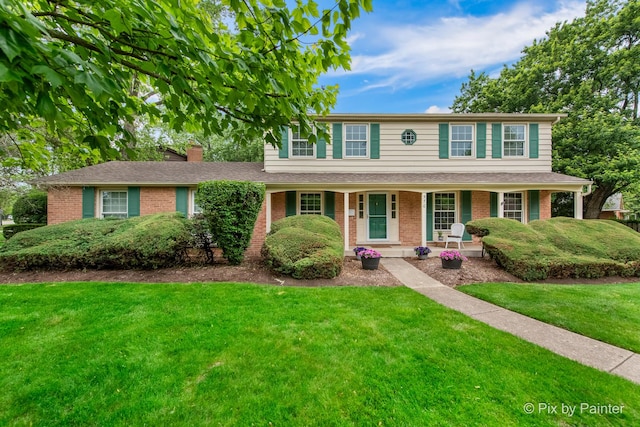 570 E Carpenter Dr, Palatine, IL 60074 - view of front of house with brick siding, a chimney, a porch, and a front lawn