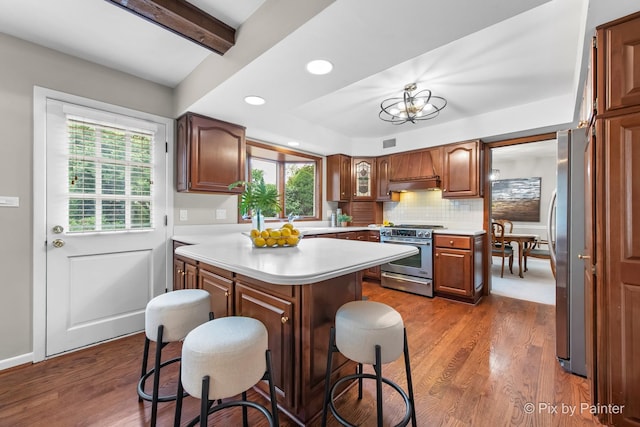 570 E Carpenter Dr, Palatine, IL 60074 - kitchen featuring stainless steel appliances, range hood, light countertops, a breakfast bar area, and decorative backsplash