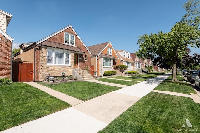 view of front of house featuring stone siding, a front yard, and a residential view
