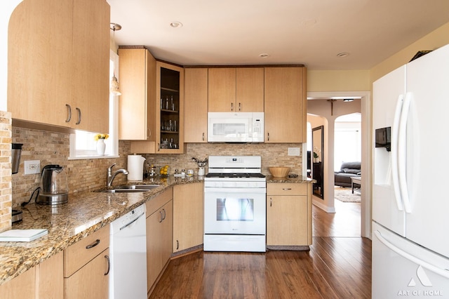 kitchen featuring white appliances, a sink, light brown cabinetry, and dark wood finished floors