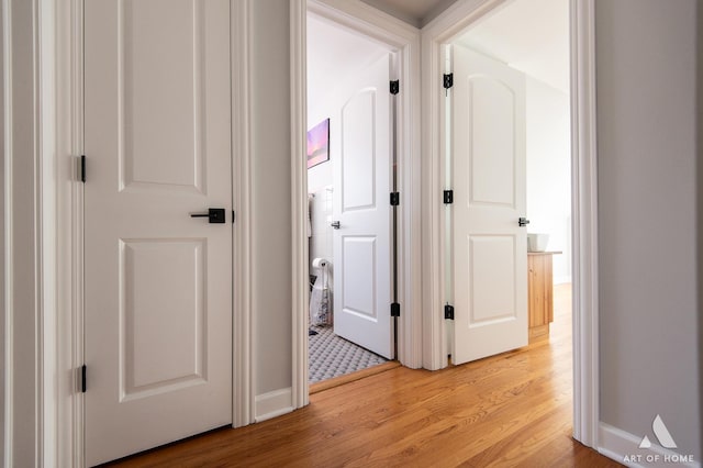 hall with light wood finished floors and baseboards