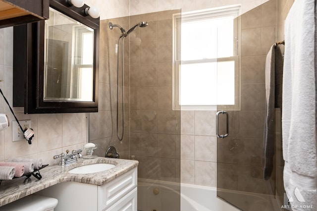full bath featuring shower / bath combination with glass door, vanity, and tasteful backsplash